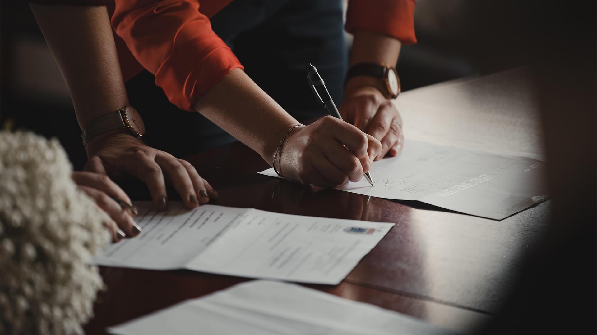 two people signing documents